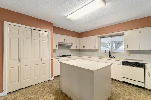 a kitchen with stainless steel appliances granite countertop white cabinets and sink