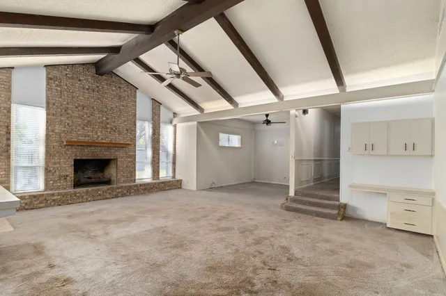 a view of an empty room with a fireplace and a window
