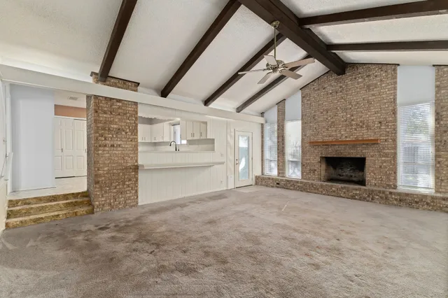 a view of empty room with wooden floor and fireplace
