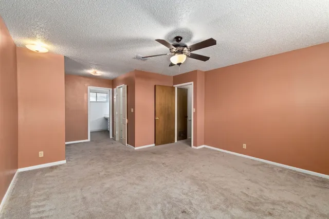 a view of an empty room and a ceiling fan