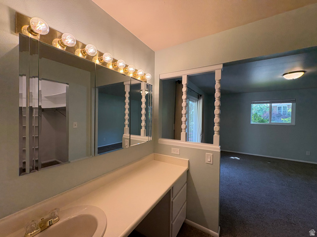 595 Meadowlark Road Orem, UT 84097 - Photo 33 of 87 Vanity area featuring a built-in countertop with an integrated sink, tri-fold mirror, and overhead vanity lighting
