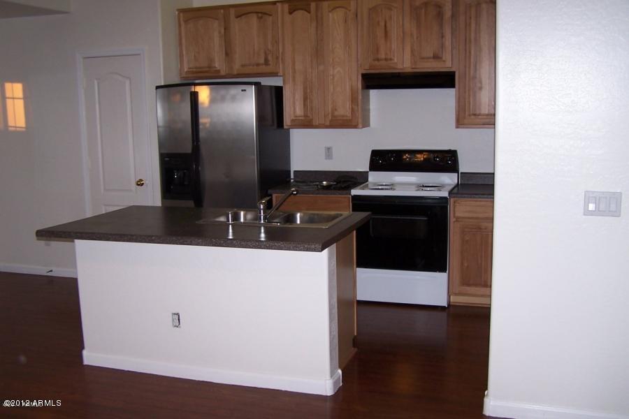 8634 West Riley Road Tolleson, AZ 85353 - Photo 9 of 12 a kitchen with stainless steel appliances granite countertop a stove and a refrigerator