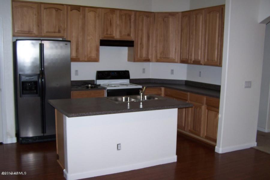 8634 West Riley Road Tolleson, AZ 85353 - Photo 10 of 12 a kitchen with a sink and a refrigerator
