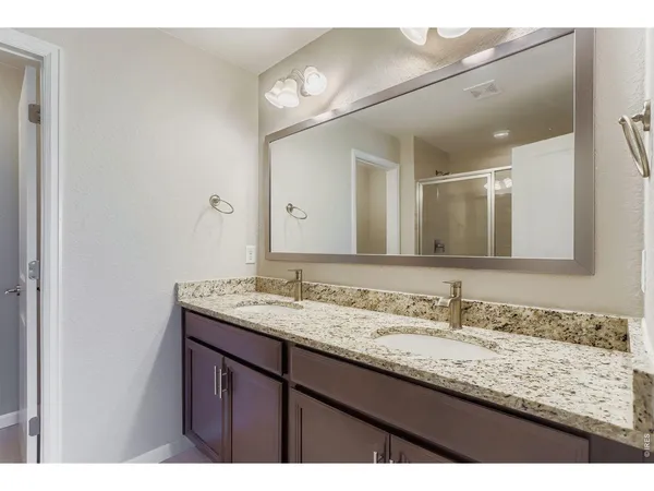 a bathroom with a granite countertop sink a large mirror and a