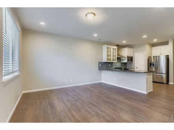 a view of kitchen with refrigerator and window