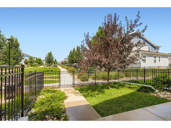 a view of a house with a big yard and a fountain