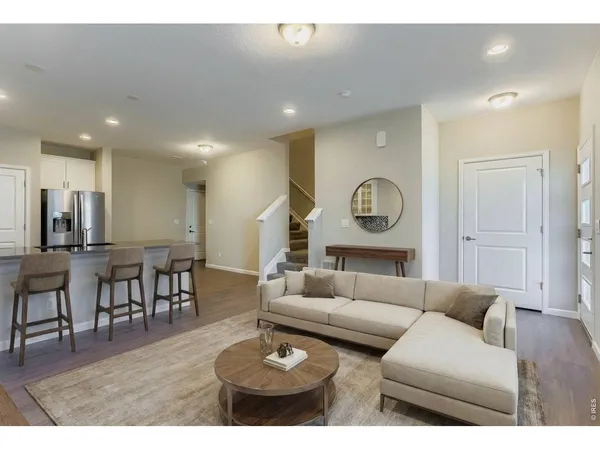 a living room with furniture kitchen and a table