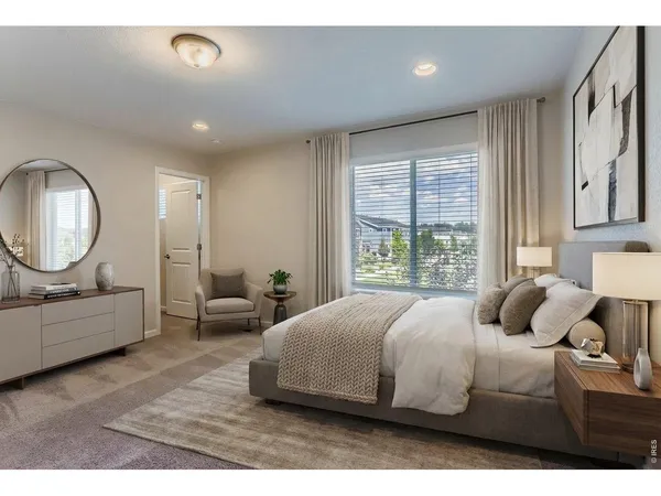 a bedroom with a bed mirror and window