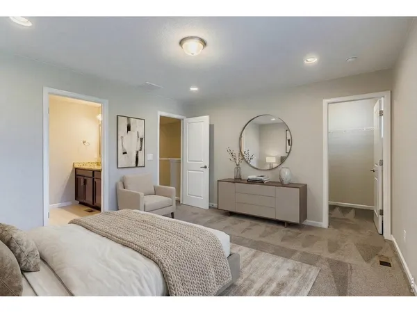 a bedroom with a bed a mirror and lamp