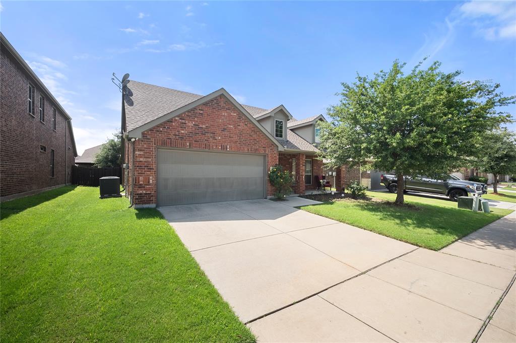 520 Rustic Oak Lane McKinney, TX 75072 - Photo 1 of 30 Brick facade residence featuring a front-facing garage with a gray door, concrete driveway, and established front yard tree