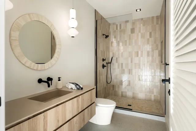 a bathroom with a sink a toilet and shower