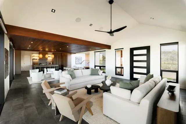 a living room with furniture a ceiling fan and a window
