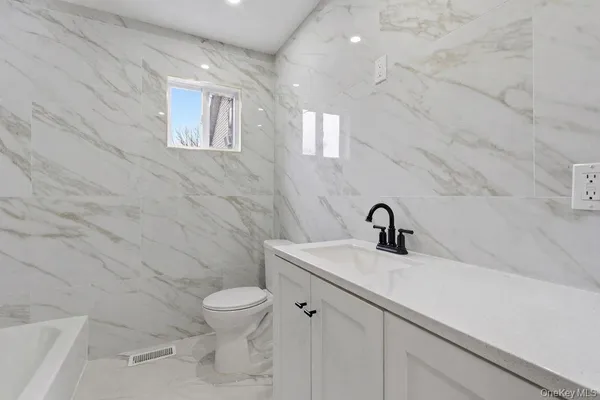 a bathroom with a sink a toilet and a mirror