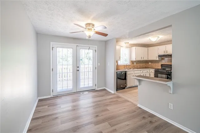 a large kitchen with cabinets wooden floor and stainless steel appliances