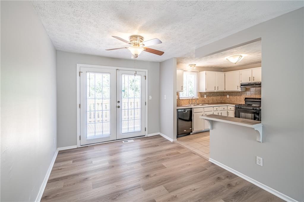 2407 Redfield Drive Norcross, GA 30071 - Photo 13 of 37 a large kitchen with cabinets wooden floor and stainless steel appliances