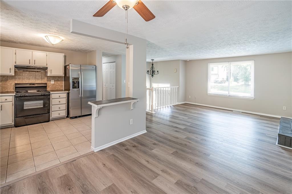 2407 Redfield Drive Norcross, GA 30071 - Photo 14 of 37 a kitchen with granite countertop a refrigerator and a stove top oven