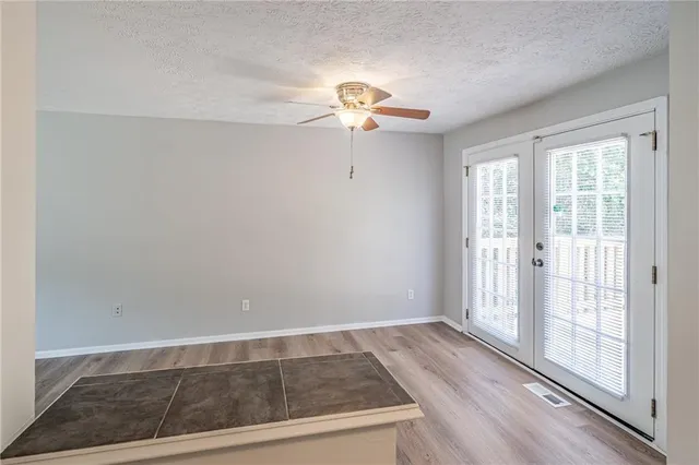 a view of a livingroom with wooden floor and a ceiling fan