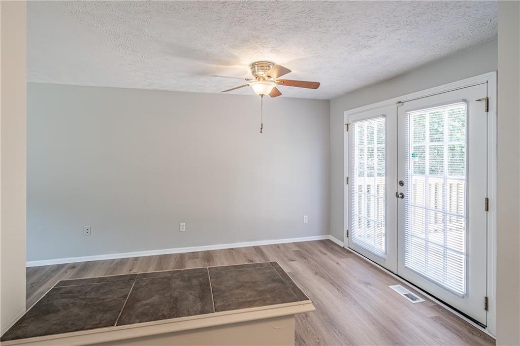 2407 Redfield Drive Norcross, GA 30071 - Photo 16 of 37 a view of a livingroom with wooden floor and a ceiling fan