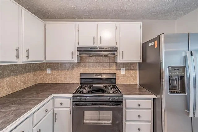 a stove top oven sitting inside of a kitchen