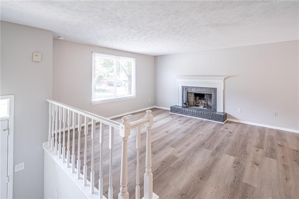 2407 Redfield Drive Norcross, GA 30071 - Photo 8 of 37 a view of empty room with fireplace and wooden floor