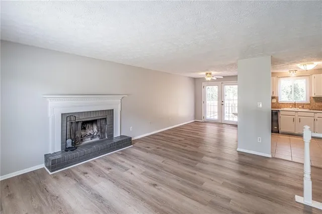 a view of a livingroom with wooden floor and a fireplace