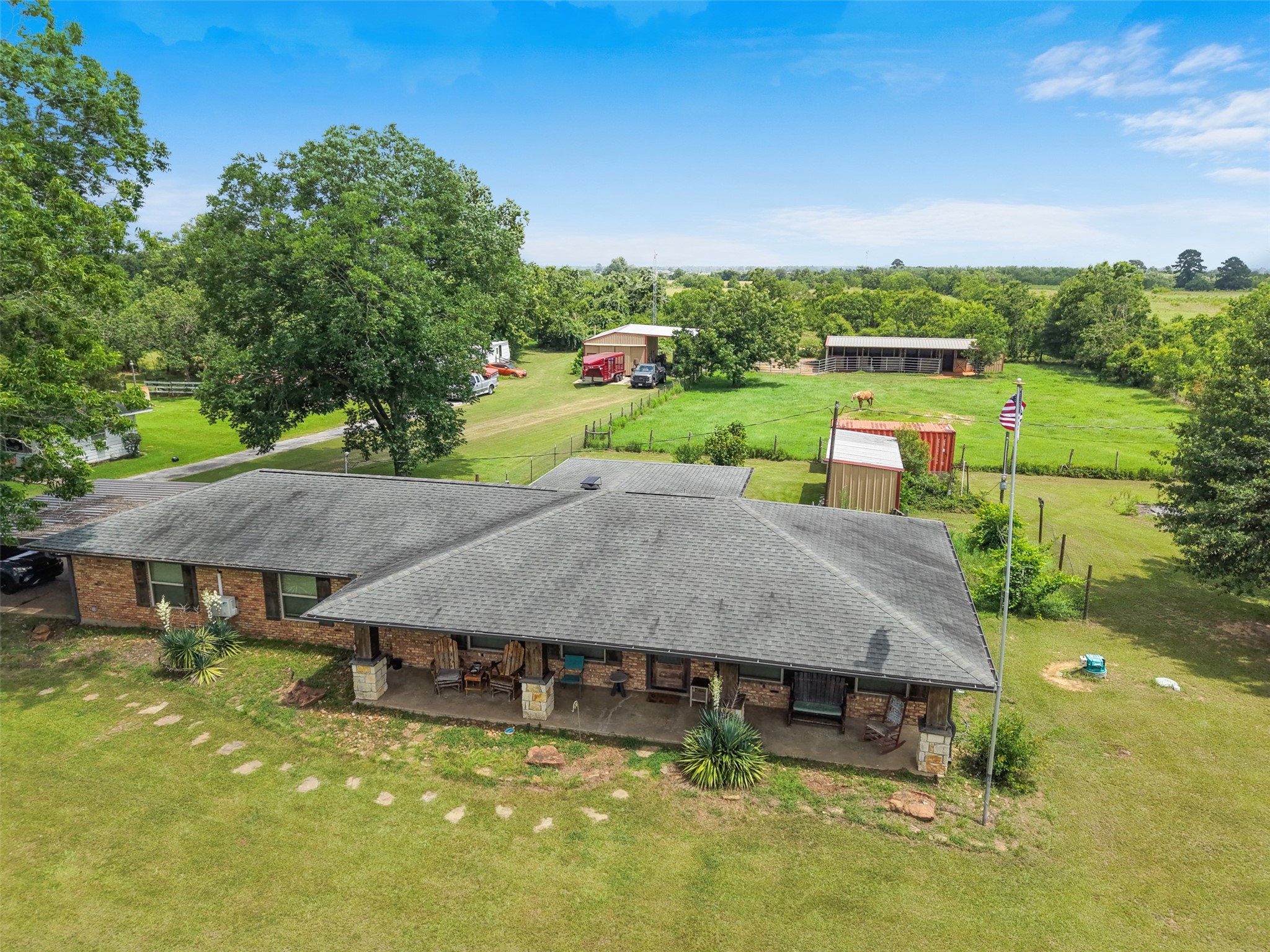34366 Owens Road Hempstead, TX 77445 - Photo 3 of 46 Elevated view highlighting the home's spacious backyard, outbuildings, mature trees, and surrounding acreage, offering a great perspective of the property's layout.