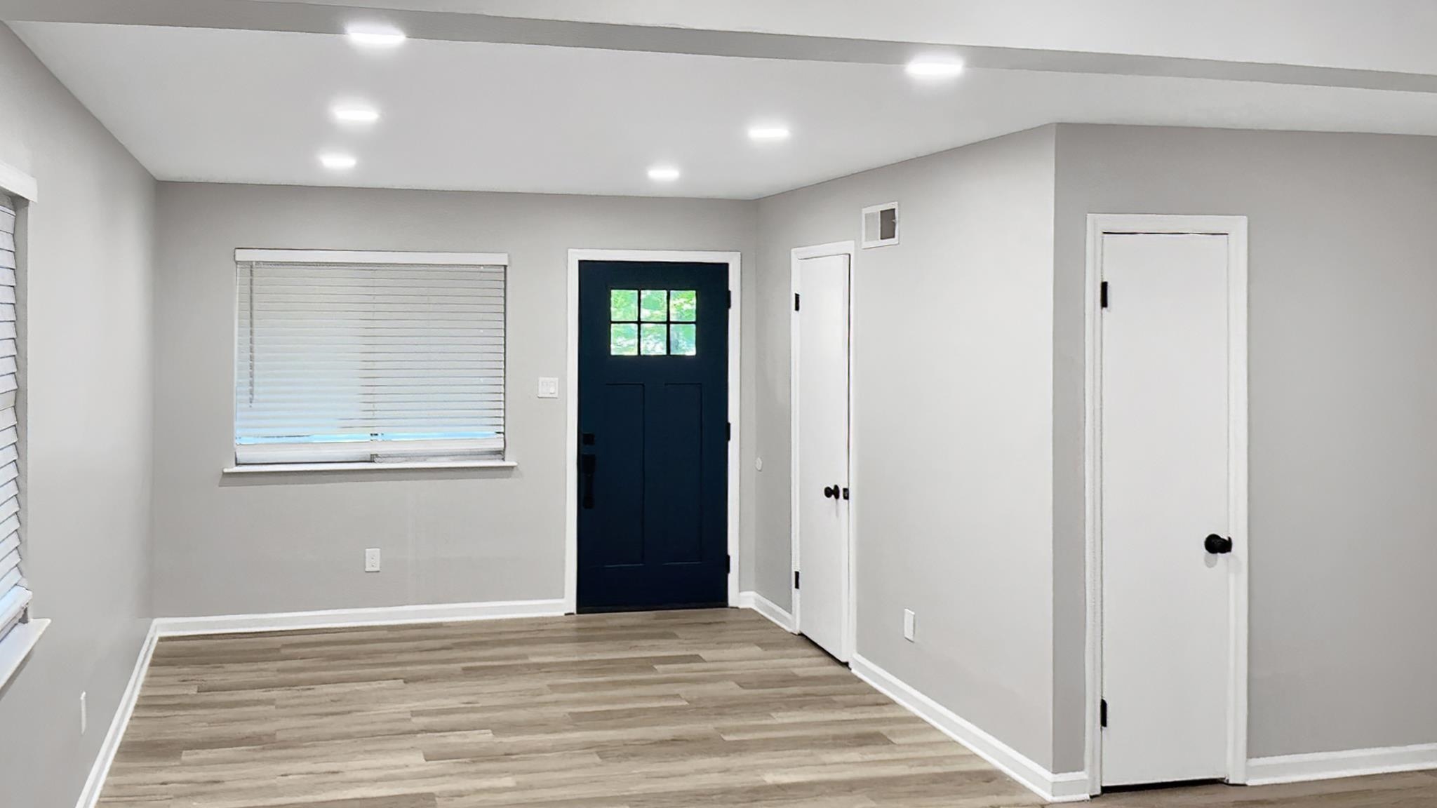 335 Homeville Road Collierville, TN 38017 - Photo 3 of 11 Entry area featuring a dark paneled door with glass inserts, light wood-finish flooring, recessed ceiling lighting, and two white panel doors with black hardware
