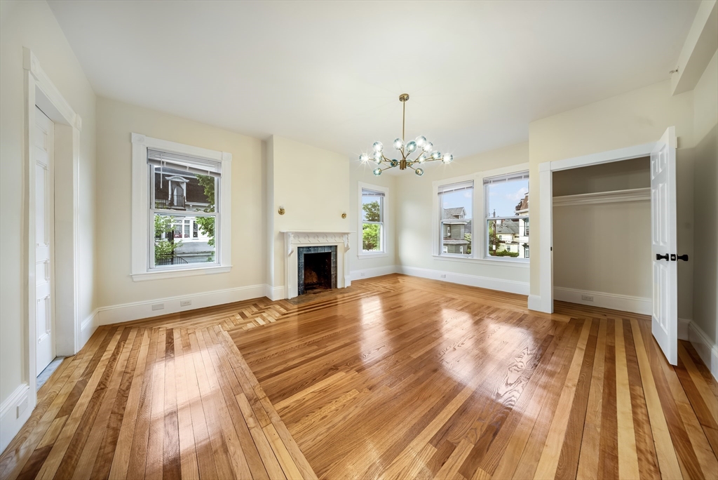 180 Jackson Street, Unit B Lawrence, MA 01841 - Photo 5 of 8 a view of empty room with wooden floor and fireplace