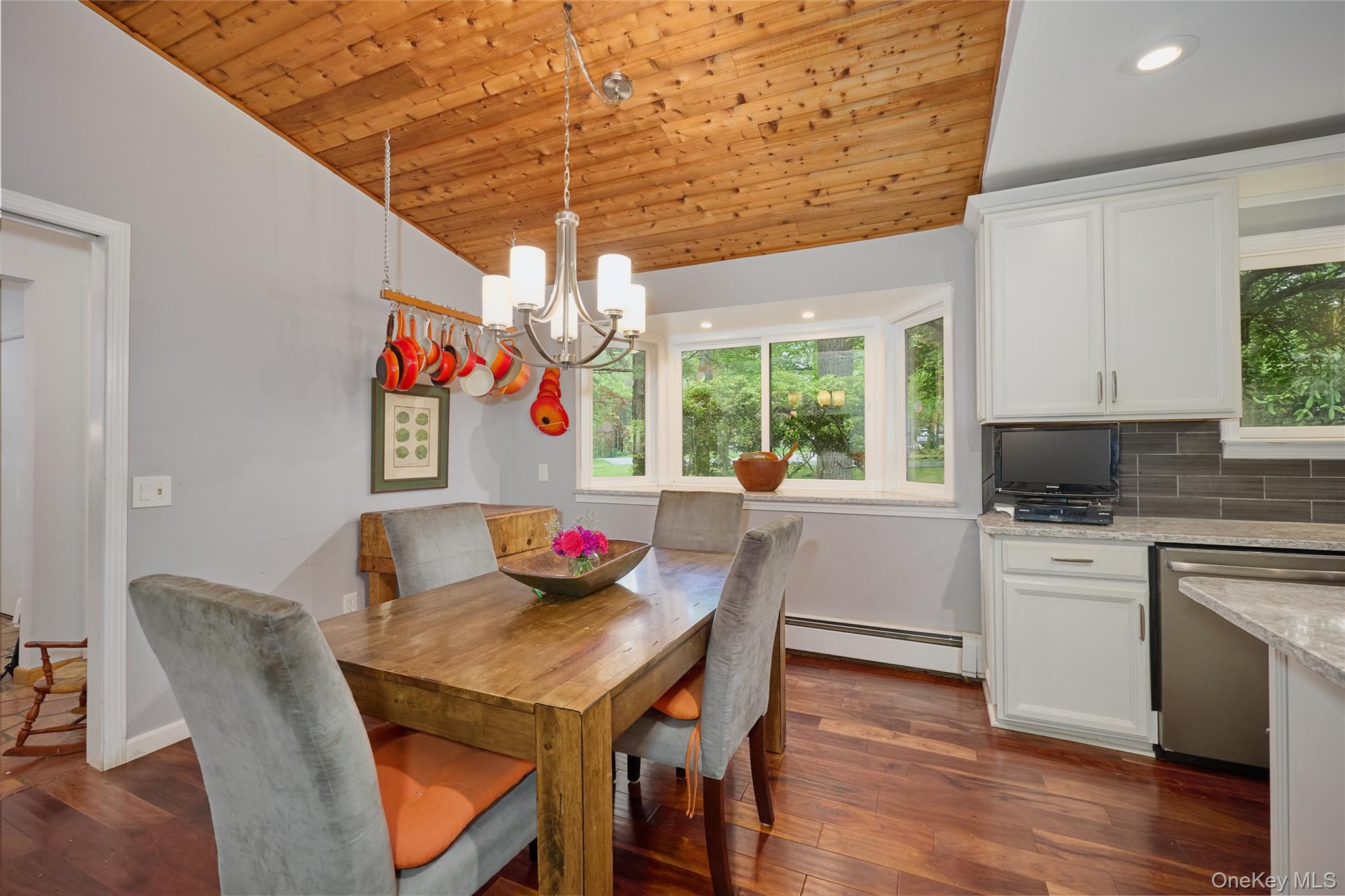 31 Greenlawn Road Katonah, NY 10536 - Photo 7 of 47 Dining room featuring a baseboard heating unit, wood ceiling, vaulted ceiling, a chandelier, and dark wood-style floors