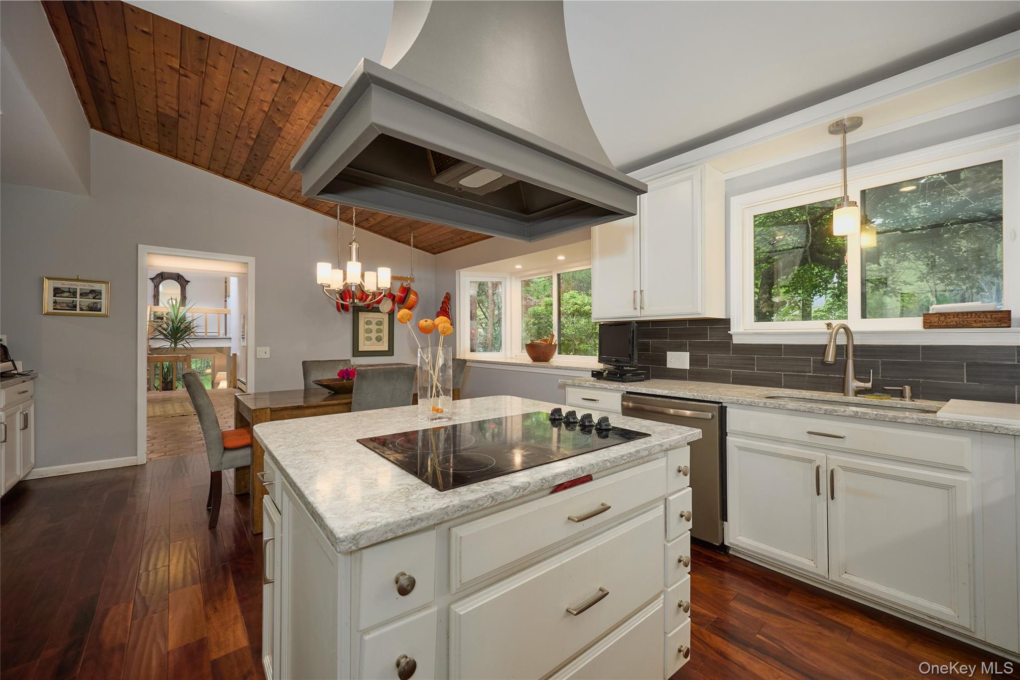 31 Greenlawn Road Katonah, NY 10536 - Photo 8 of 47 Kitchen with black electric cooktop, vaulted ceiling, custom range hood, stainless steel dishwasher, and a sink