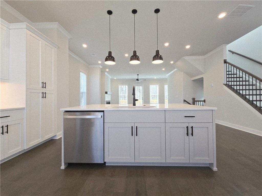 163 Basil Street Cumming, GA 30040 - Photo 12 of 56 a view of a kitchen with a sink and dishwasher with wooden floor