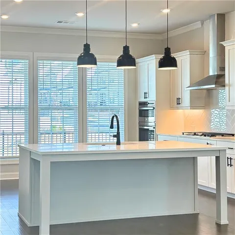 a kitchen with stainless steel appliances granite countertop a stove a sink and a window