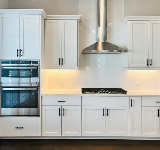 a kitchen with granite countertop white cabinets and white appliances