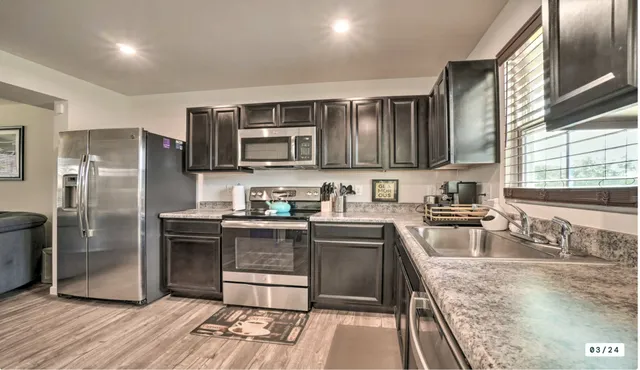 a kitchen with stainless steel appliances granite countertop a refrigerator stove and sink