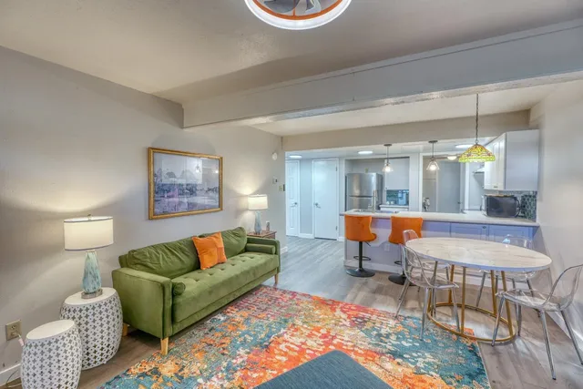 a room with kitchen island a sink and a stove with wooden floor