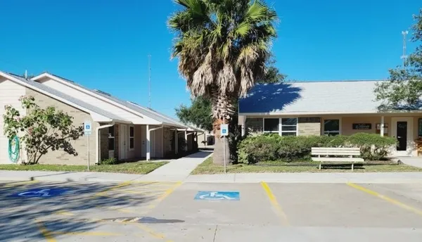 a front view of a house with a garden and parking