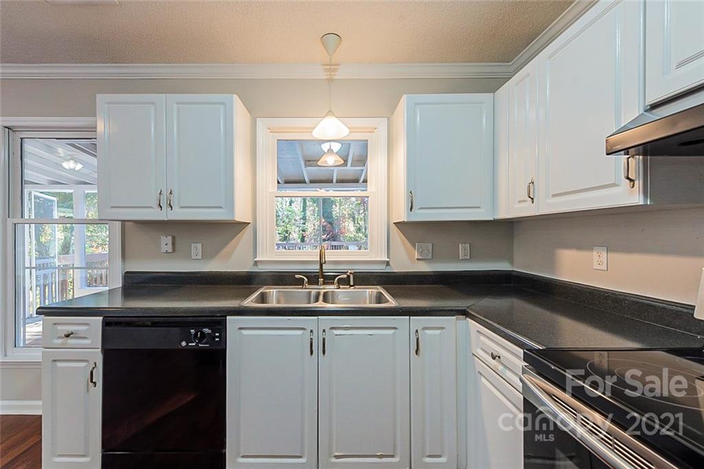 4059 Point Clear Drive Tega Cay, SC 29708 - Photo 5 of 16 a kitchen with granite countertop a sink a window and cabinets