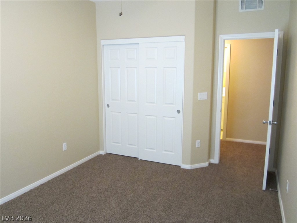7701 West Robindale Road, Unit 262 Las Vegas, NV 89113 - Photo 19 of 26 A well-proportioned room featuring cozy carpeting and practical sliding closet doors.