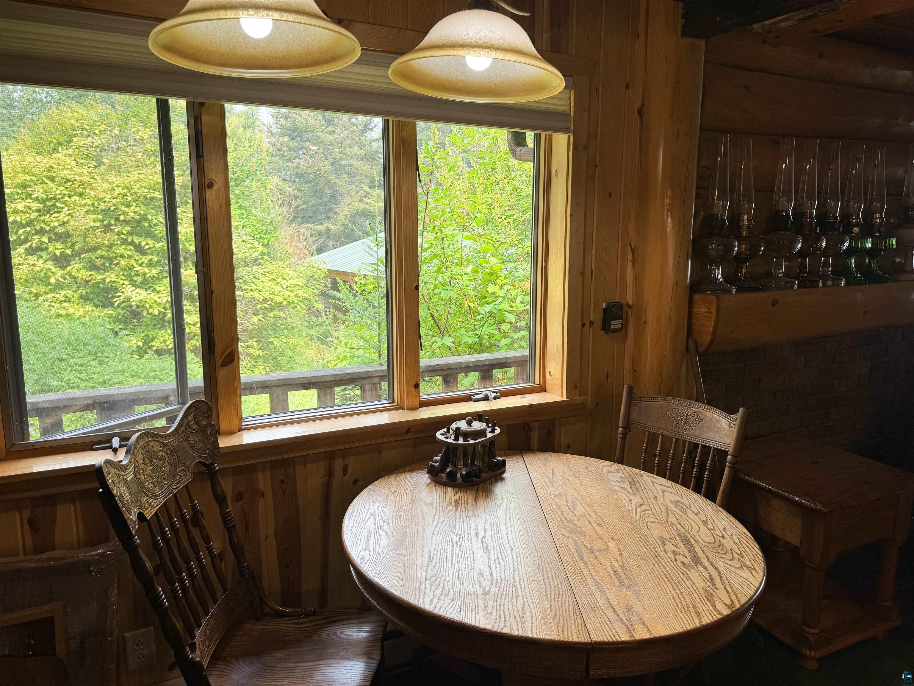 465 South Gunflint Lake Road Grand Marais, MN 55604 - Photo 20 of 46 Wood-paneled interior featuring a large window overlooking a wooded landscape