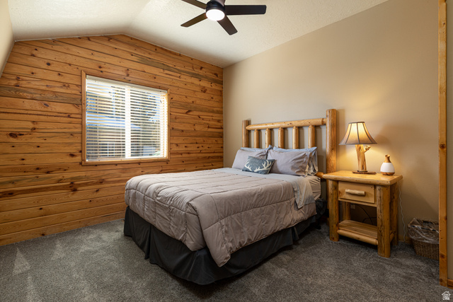 1505 West Elk Ridge Drive Alton, UT 84710 - Photo 23 of 53 Bedroom with wood walls, vaulted ceiling, carpet flooring, ceiling fan, and a textured ceiling