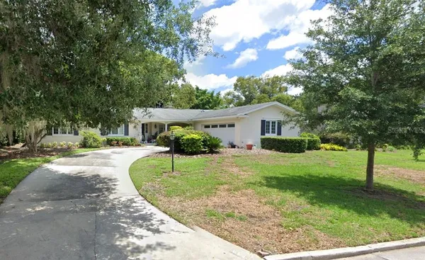a view of a house with backyard and a tree