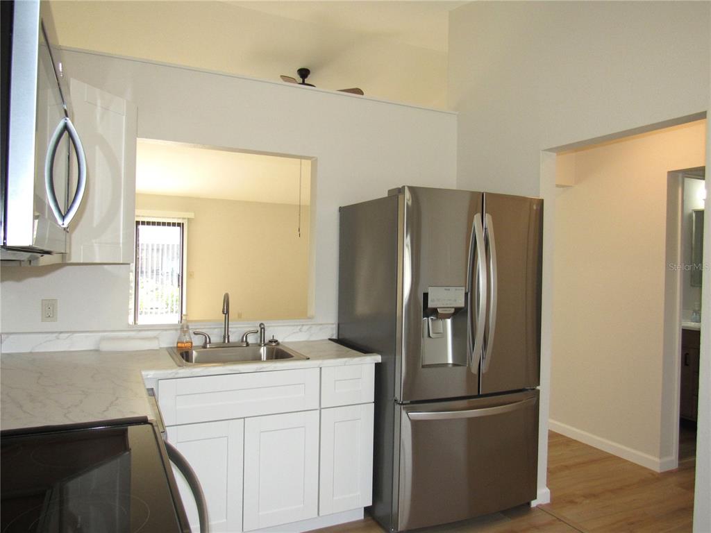 20005 Goldcup Court Port Charlotte, FL 33952 - Photo 11 of 33 a kitchen with stainless steel appliances a refrigerator sink and cabinets