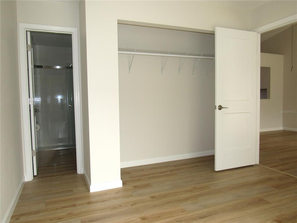 20005 Goldcup Court Port Charlotte, FL 33952 - Photo 14 of 33 a view of an empty room with wooden floor and a bathroom