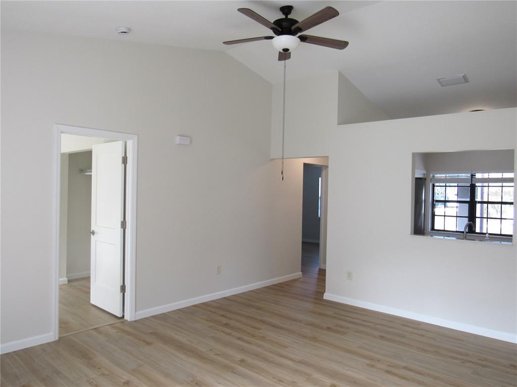 20005 Goldcup Court Port Charlotte, FL 33952 - Photo 9 of 33 a view of an empty room with wooden floor and a ceiling fan