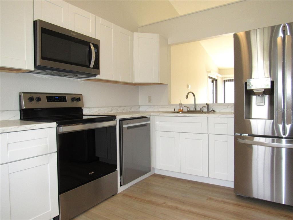 20005 Goldcup Court Port Charlotte, FL 33952 - Photo 10 of 33 a kitchen with a sink stove and microwave