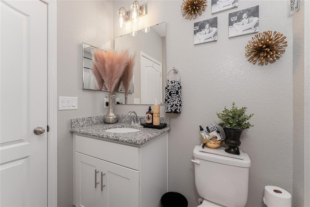 25381 Rupert Road Punta Gorda, FL 33983 - Photo 31 of 58 a bathroom with a granite countertop sink a toilet and mirror