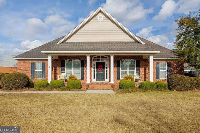 a front view of a house with a garden and plants