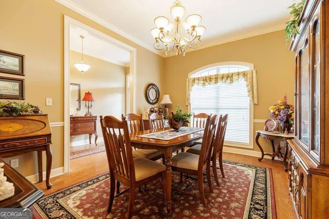 a view of a dining room with furniture a chandelier and wooden floor
