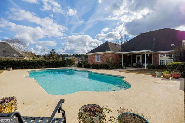 a view of a house with swimming pool and a yard