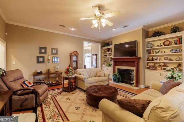 a living room with furniture a flat screen tv and a fireplace
